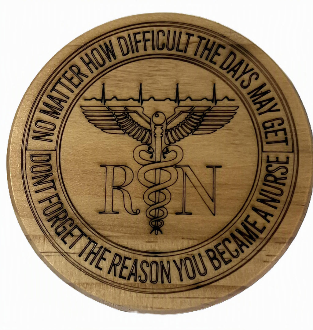 A round wooden coaster featuring a laser-engraved RN medical symbol with a caduceus wing design and motivational text around the border.